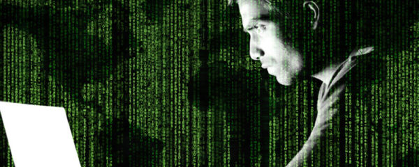 hacker devant son écran d'ordinateur avec un code informatique et une carte du monde